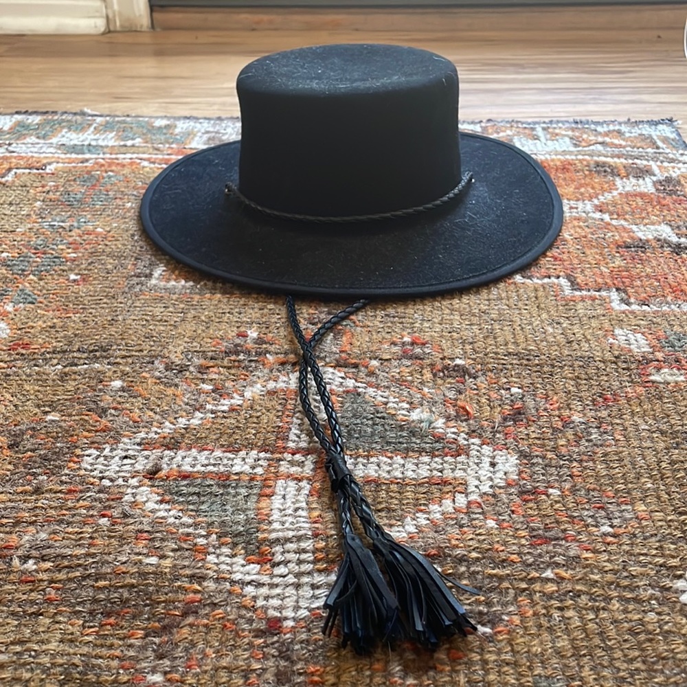 Black wool hat with leather braided strap and adjustable band.size small.